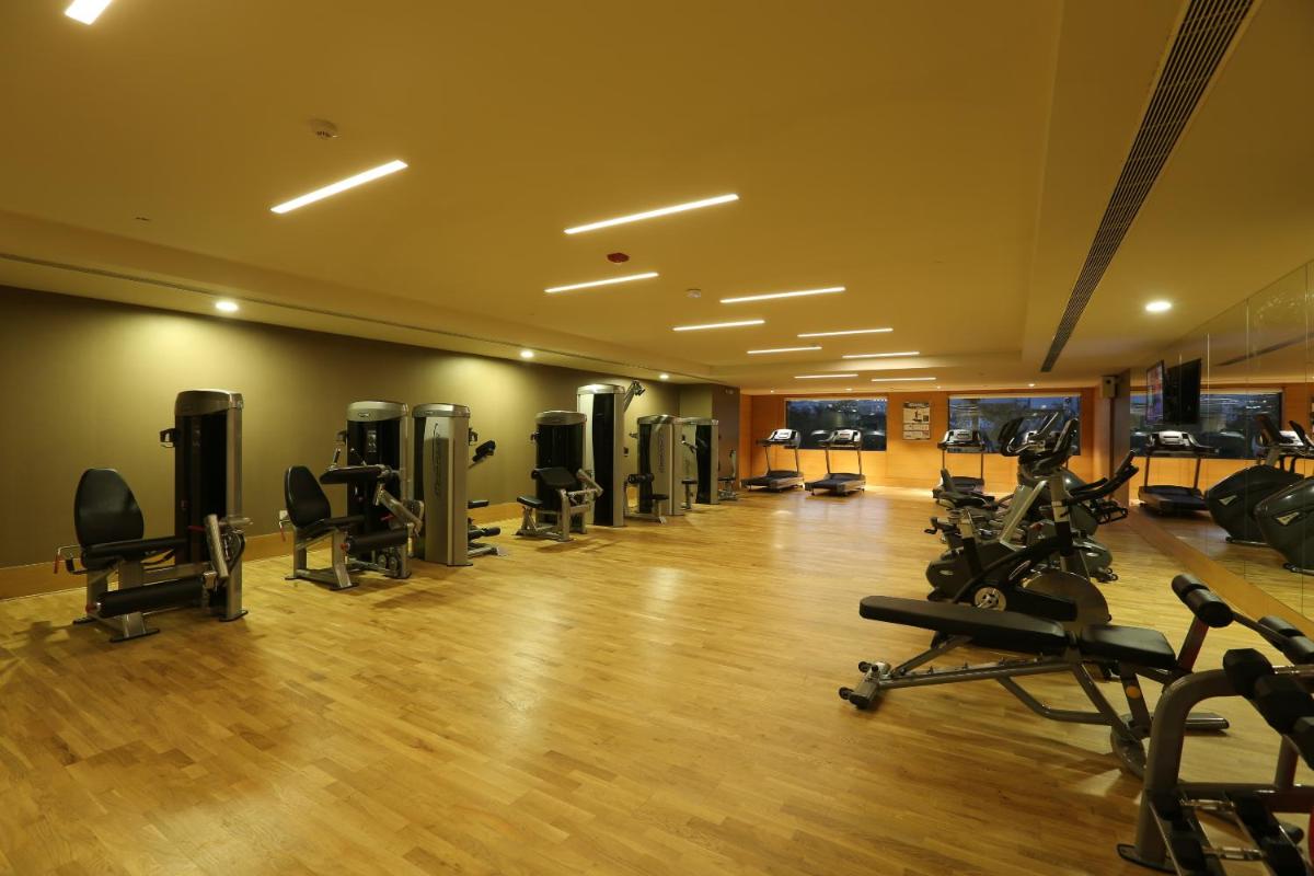 a gym with several treadmills and exercise bikes at Feathers- A Radha Hotel, Chennai in Chennai