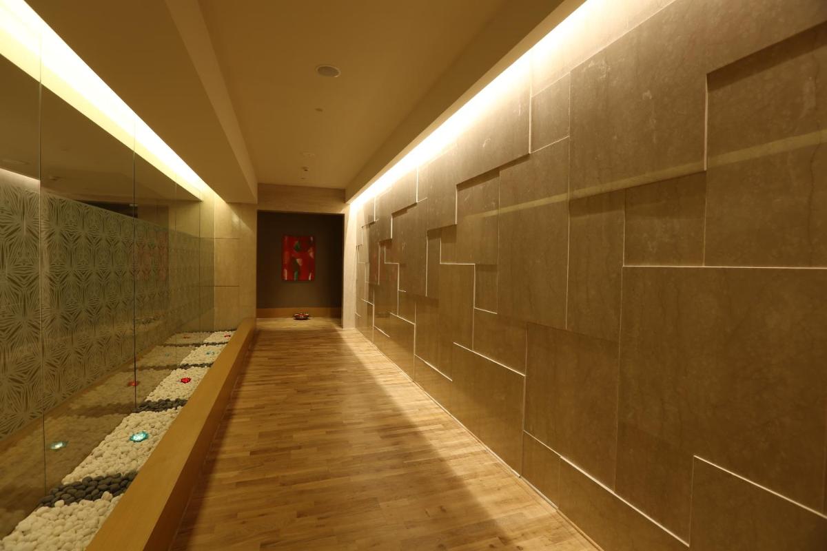 a hallway with a long corridor with tile walls at Feathers- A Radha Hotel, Chennai in Chennai