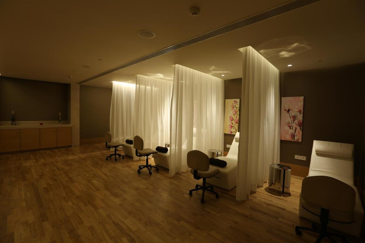 a hospital room with two beds and two chairs at Feathers- A Radha Hotel, Chennai in Chennai