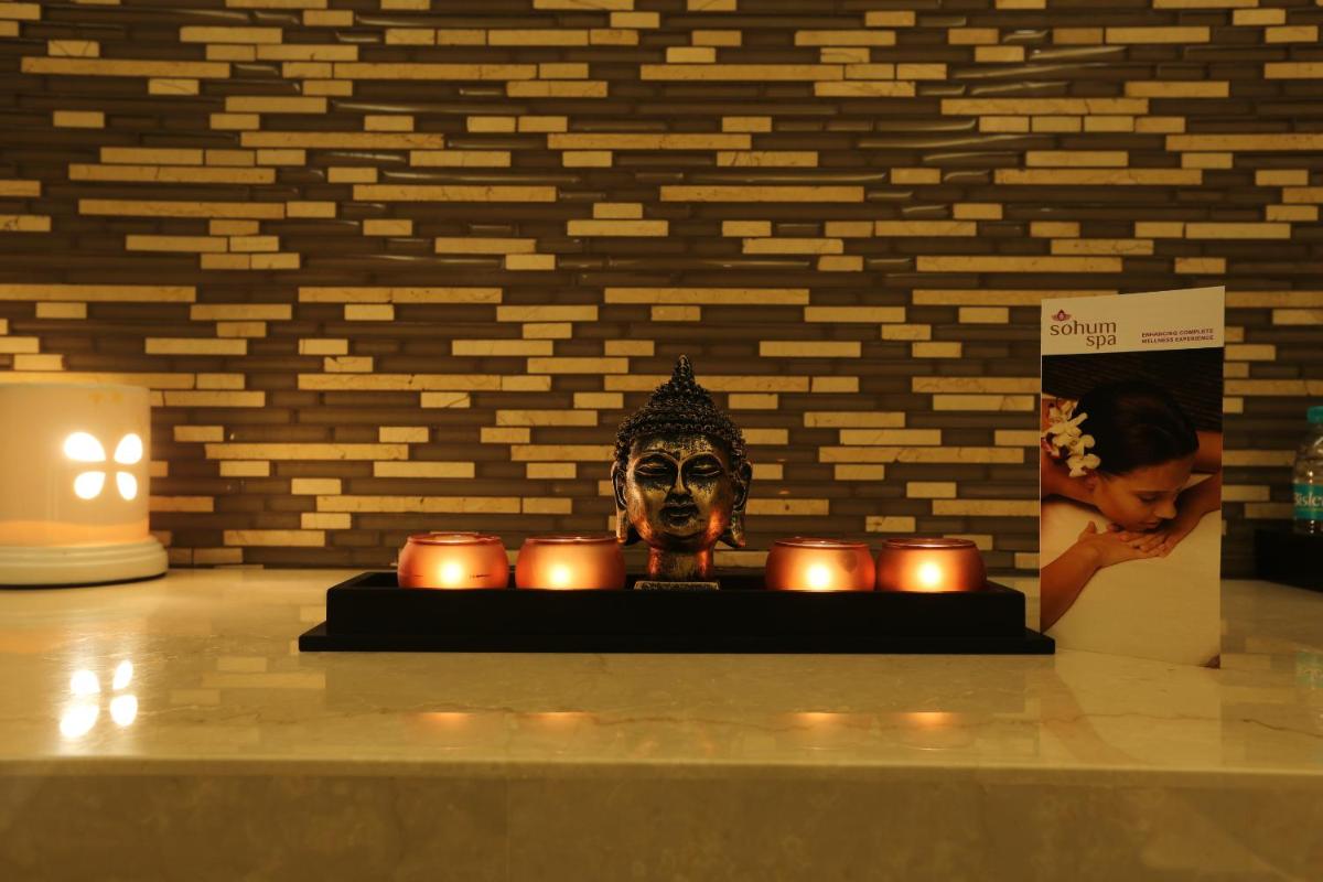 a statue with candles in front of a wall at Feathers- A Radha Hotel, Chennai in Chennai