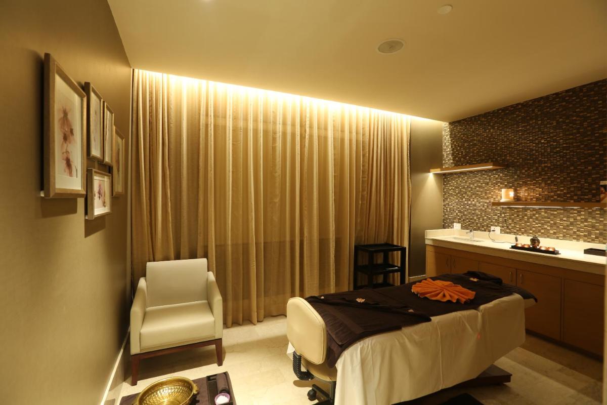 a hotel room with a bed and a sink at Feathers- A Radha Hotel, Chennai in Chennai