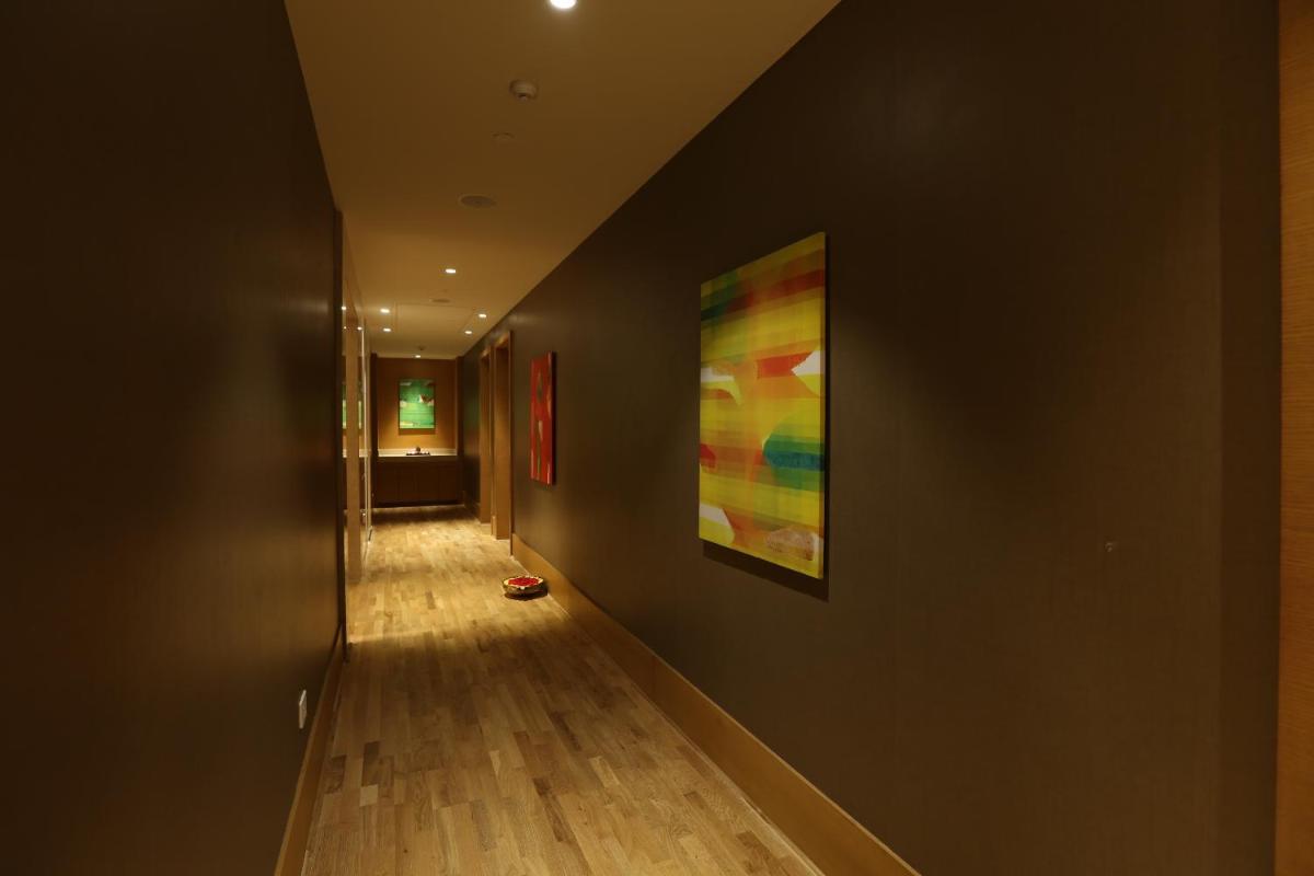 a hallway with a painting hanging on a wall at Feathers- A Radha Hotel, Chennai in Chennai