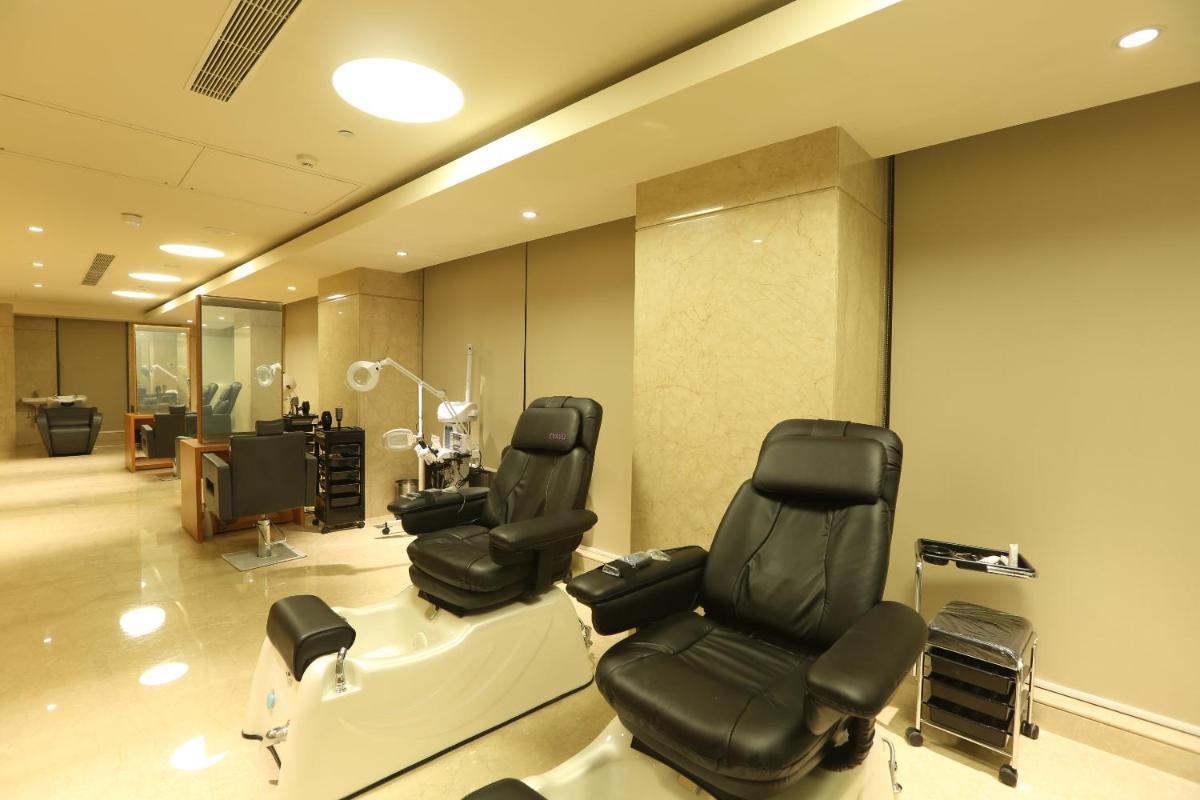 a salon with two chairs and a computer monitor at Feathers- A Radha Hotel, Chennai in Chennai