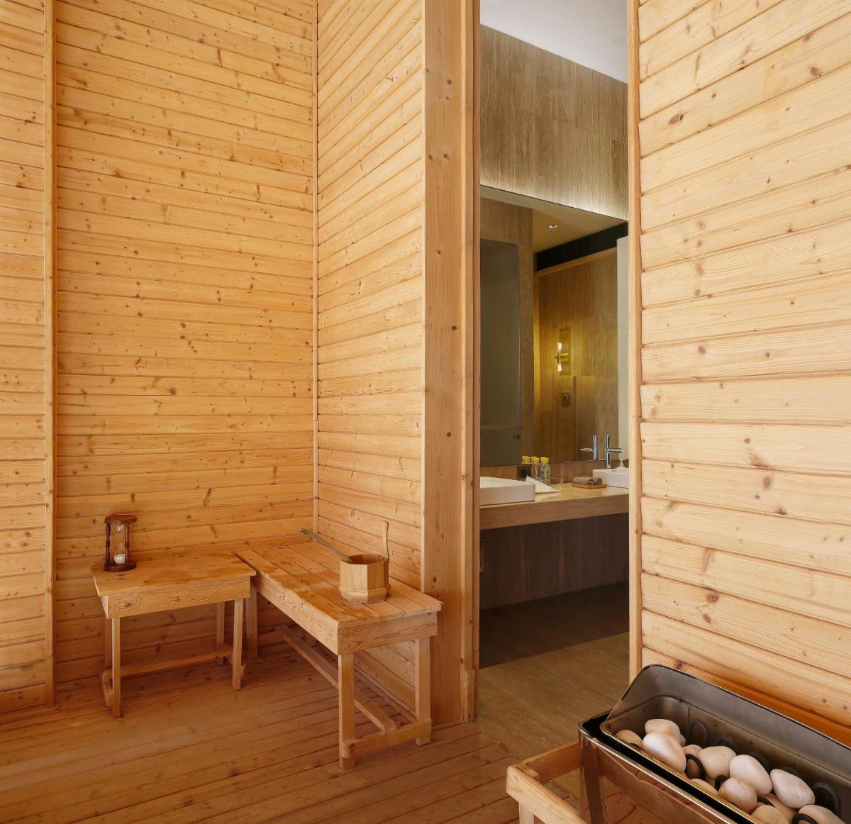 a sauna with a bench and a sink at Roseate House New Delhi in New Delhi a sauna with a bench and a sink at Roseate House New Delhi in New Delhi