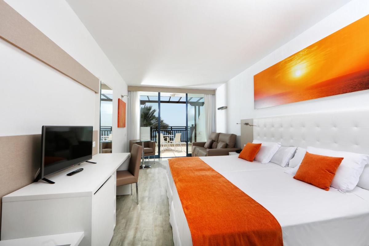 Un dormitorio con una cama grande y un televisor. en Sandos Papagayo, en Playa Blanca 58 fotos más