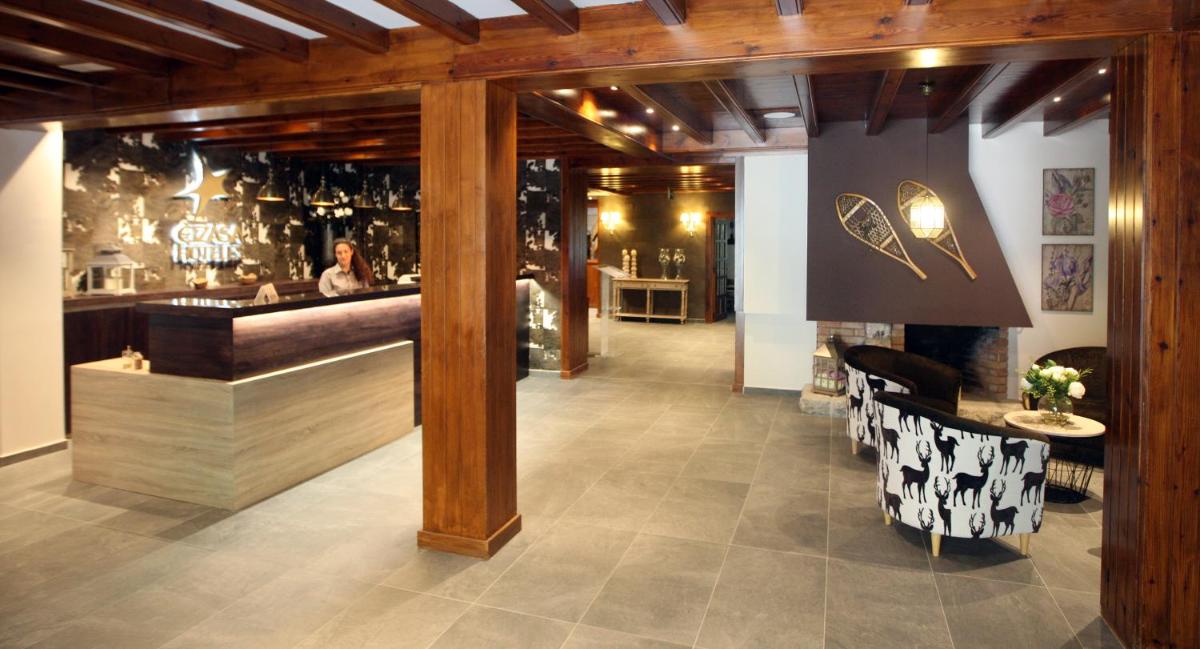 un restaurante con bar con mesa y barra en Hotel & Spa Real Villa Anayet, en Canfranc-Estación