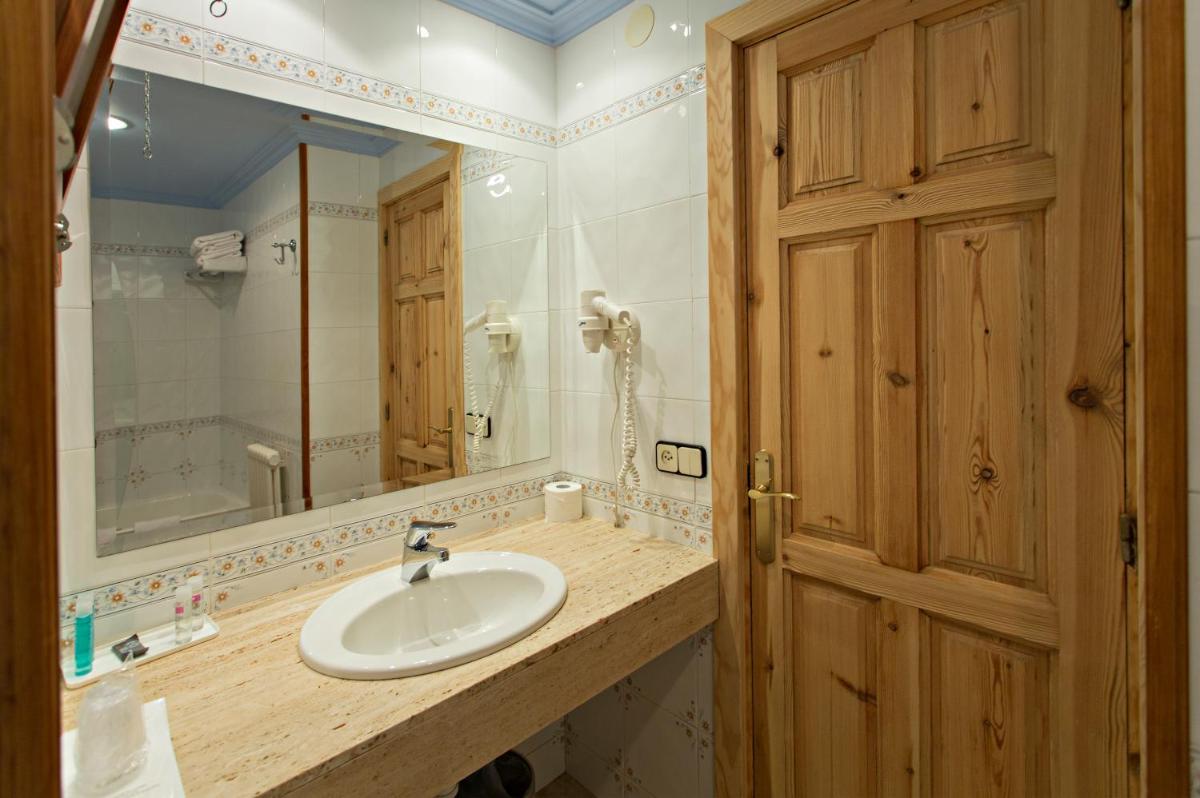 un baño con lavabo y espejo en Hotel La Coma, en Setcases