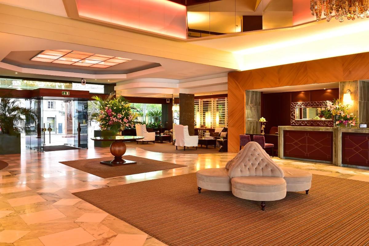 um lobby de um hotel com uma cadeira e mesas em Pestana Madeira Beach Club no Funchal mais 12 fotografias