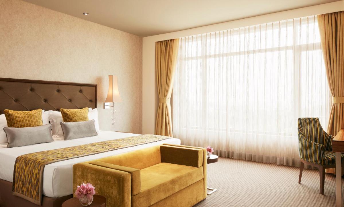 a hotel room with a bed and a window at Taj Swarna, Amritsar in Amritsar