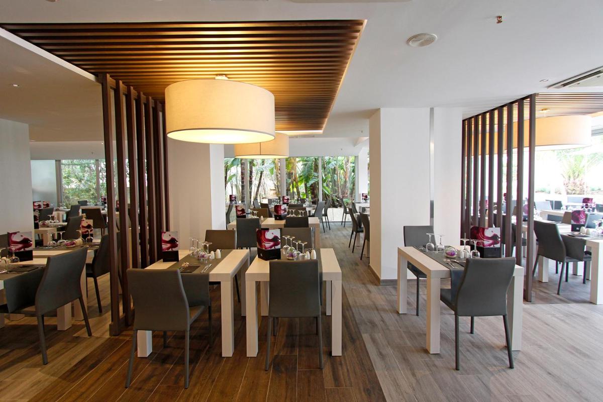 Un comedor con mesas y sillas en un restaurante. en BG Pamplona, en Playa de Palma