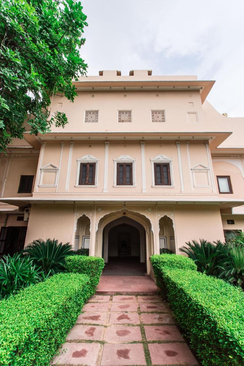 an exterior view of a building with green bushes at Royal Heritage Haveli - By Leisure Hotels in Jaipur