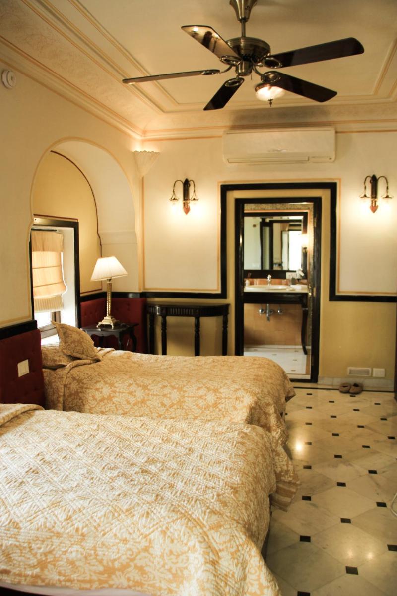 a bedroom with a bed and a ceiling fan at Royal Heritage Haveli - By Leisure Hotels in Jaipur