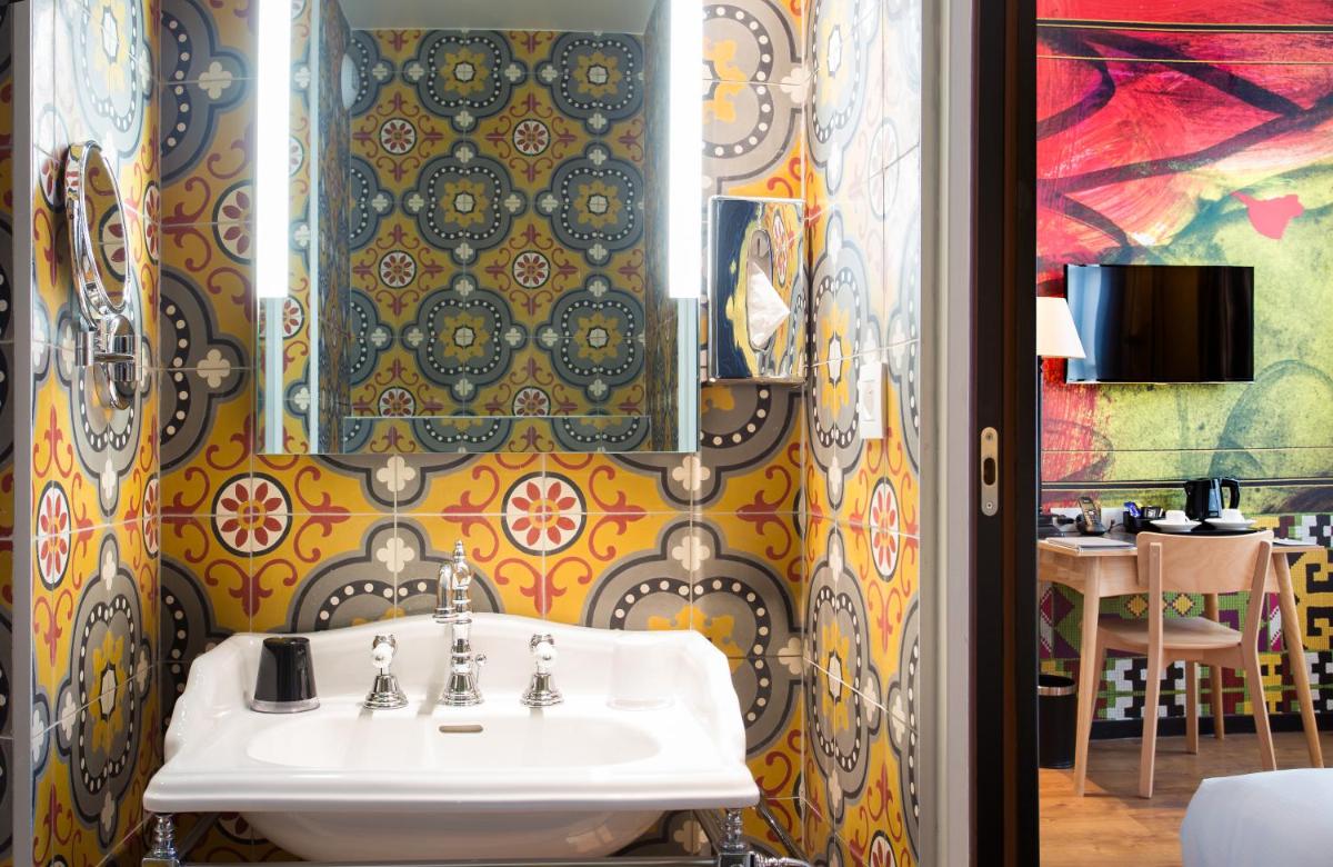 La salle de bains est pourvue d'un lavabo et d'une table. dans l'établissement Hotel L’Antoine, à Paris