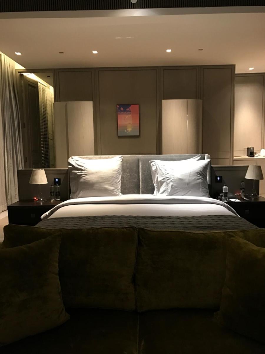 a bedroom with a large bed with white pillows at Roseate House New Delhi in New Delhi a bedroom with a large bed with white pillows at Roseate House New Delhi in New Delhi