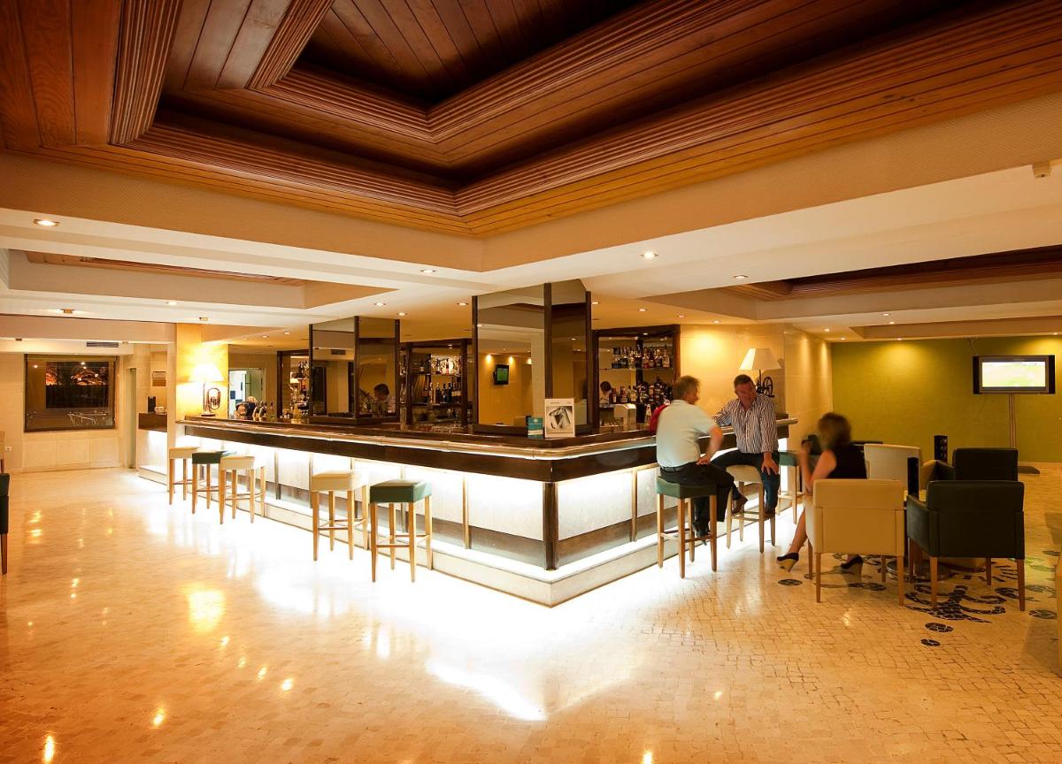 um lobby com um bar com pessoas sentadas nas mesas em Vila Gale Ampalius em Vilamoura