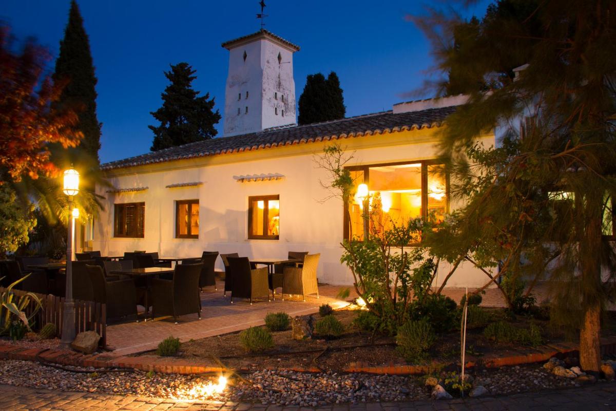 Un edificio con una mesa y sillas delante. en Hotel & Spa La Salve, en Torrijos