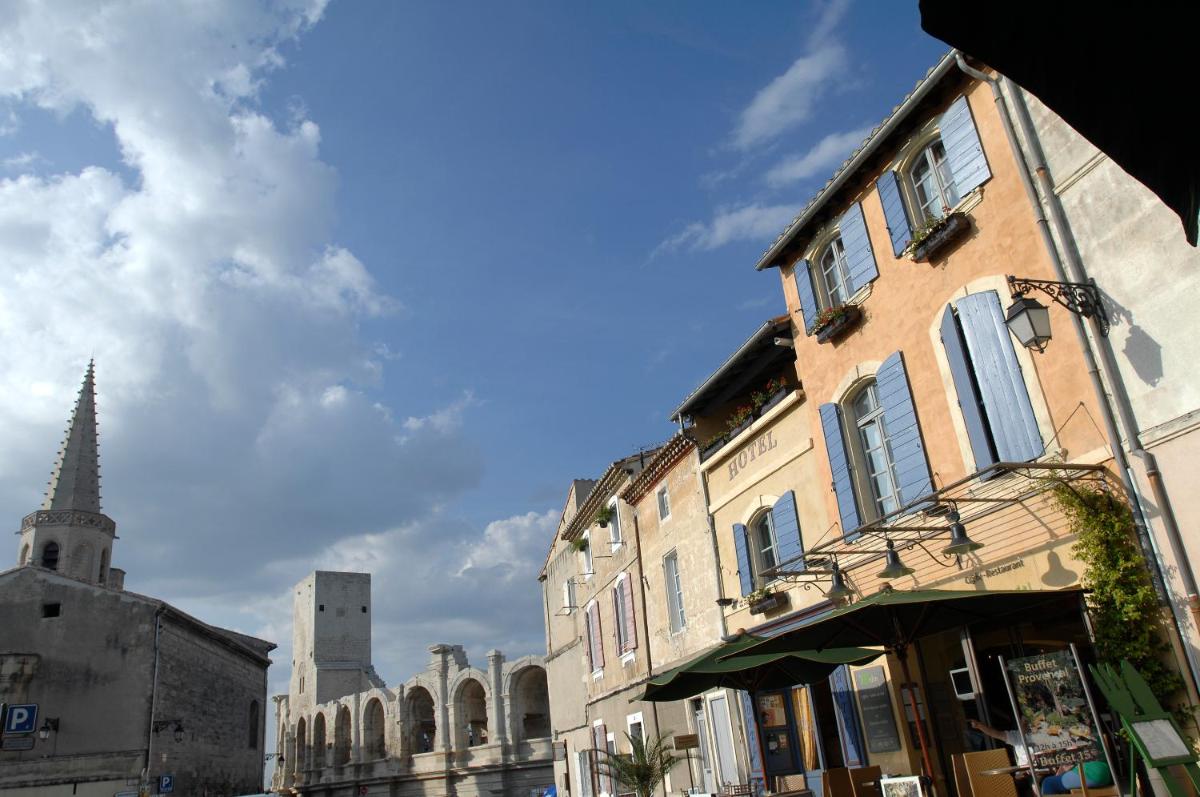 un bâtiment avec un clocher et un bâtiment avec une église dans l'établissement Hotel Spa Le Calendal, à Arles