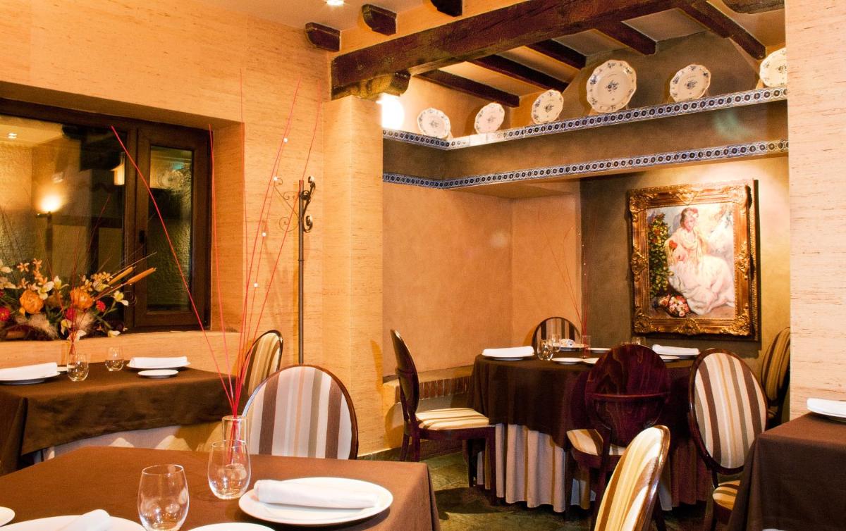 un restaurante con mesas y sillas y una pintura en la pared en Hotel & Spa La Salve, en Torrijos