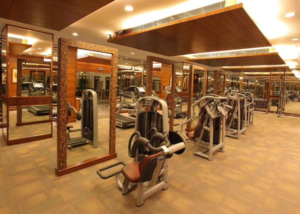 a gym with a row of treadmills and ellipticals at The Lalit Mumbai in Mumbai