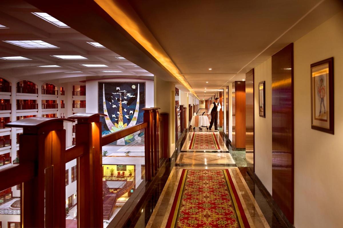 a hallway in a building with a rug on the floor at The Lalit Mumbai in Mumbai