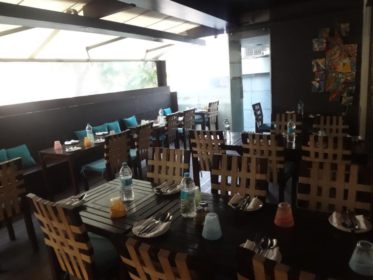 a dining room with a long table and chairs at Svenska Design Hotel in Mumbai