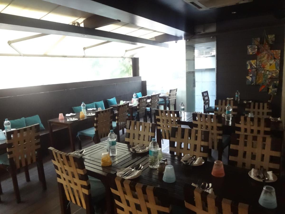 a dining room with a long table and chairs at Svenska Design Hotel in Mumbai