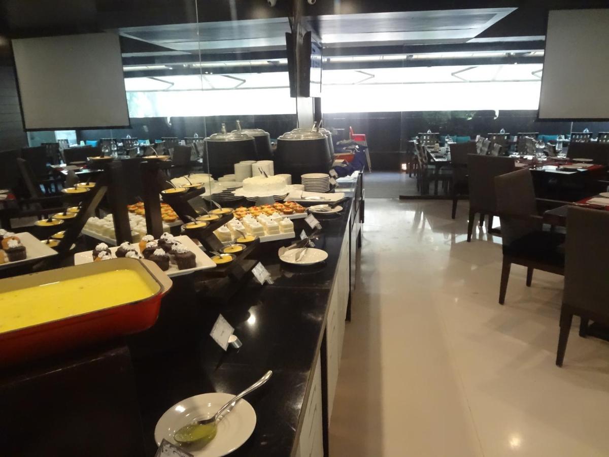 a restaurant with a buffet line with plates of food at Svenska Design Hotel in Mumbai