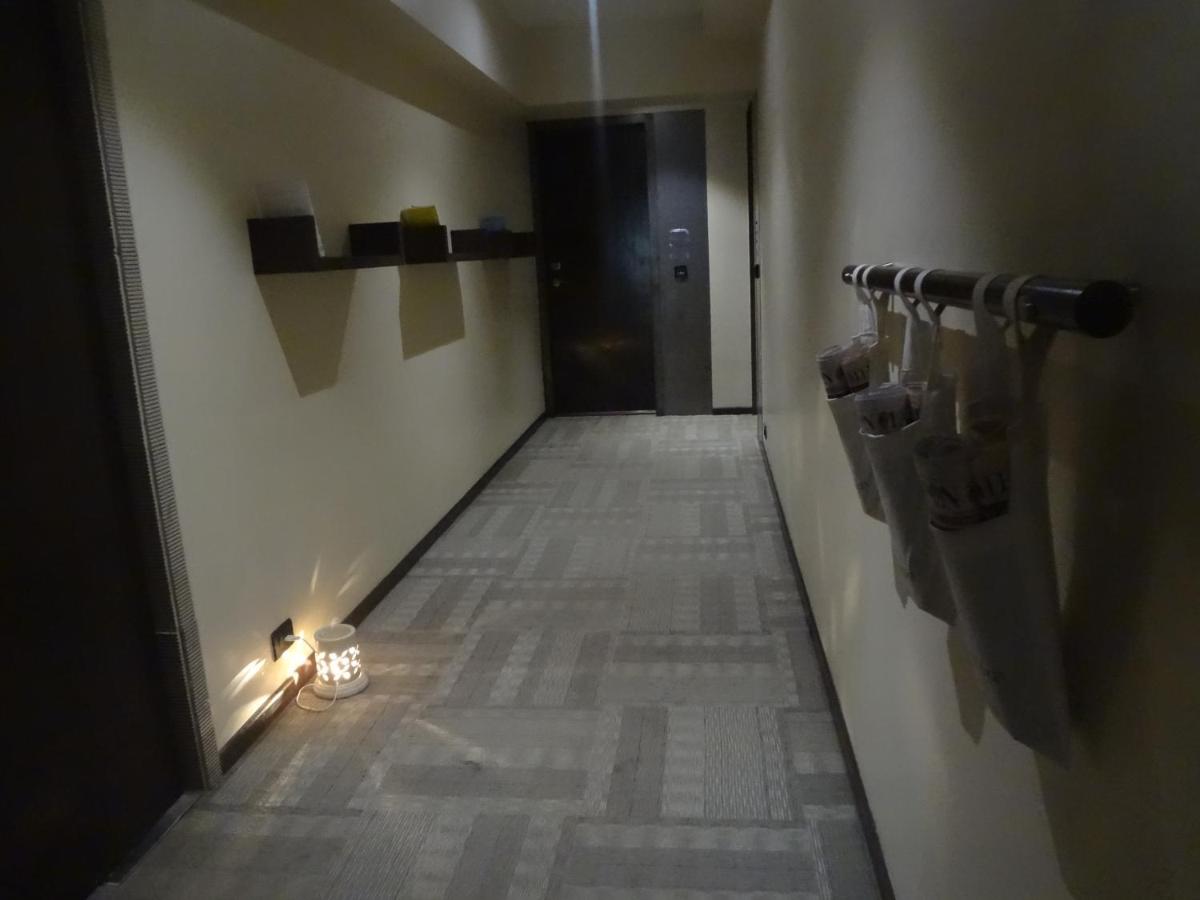 a long hallway with a light on the wall and a hallway at Svenska Design Hotel in Mumbai