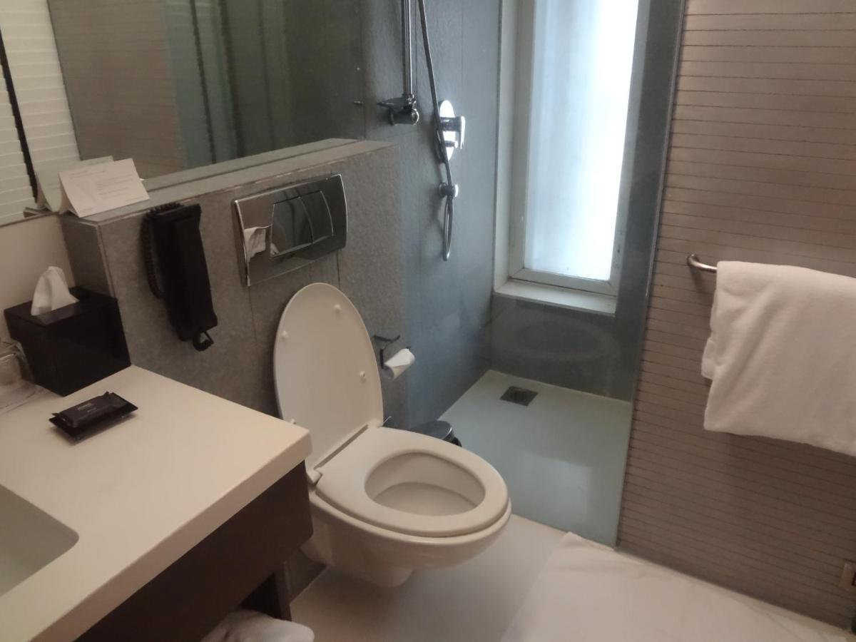 a bathroom with a toilet and a sink and a shower at Svenska Design Hotel in Mumbai