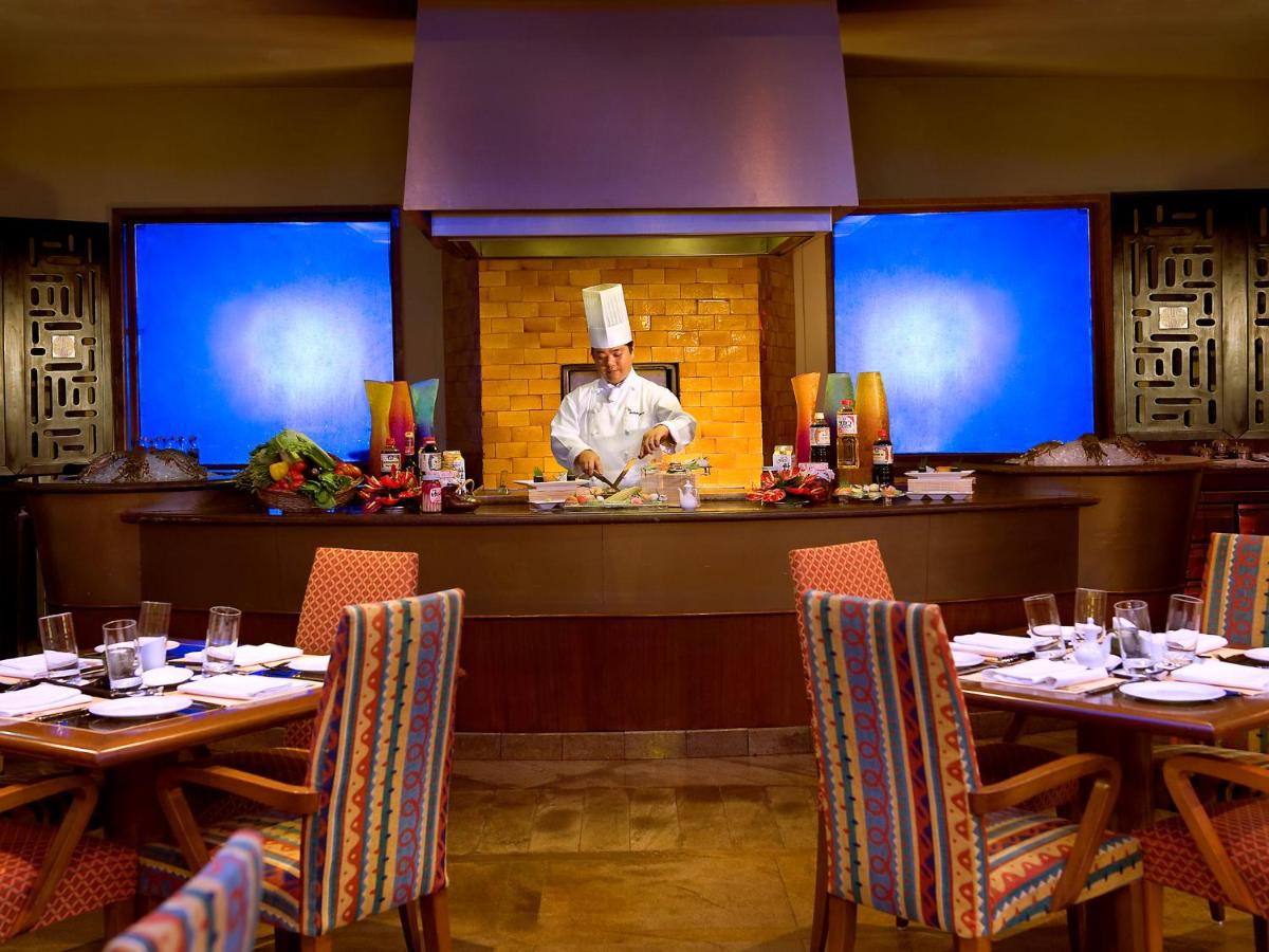 a chef is standing behind the counter in a restaurant at The Lalit Mumbai in Mumbai