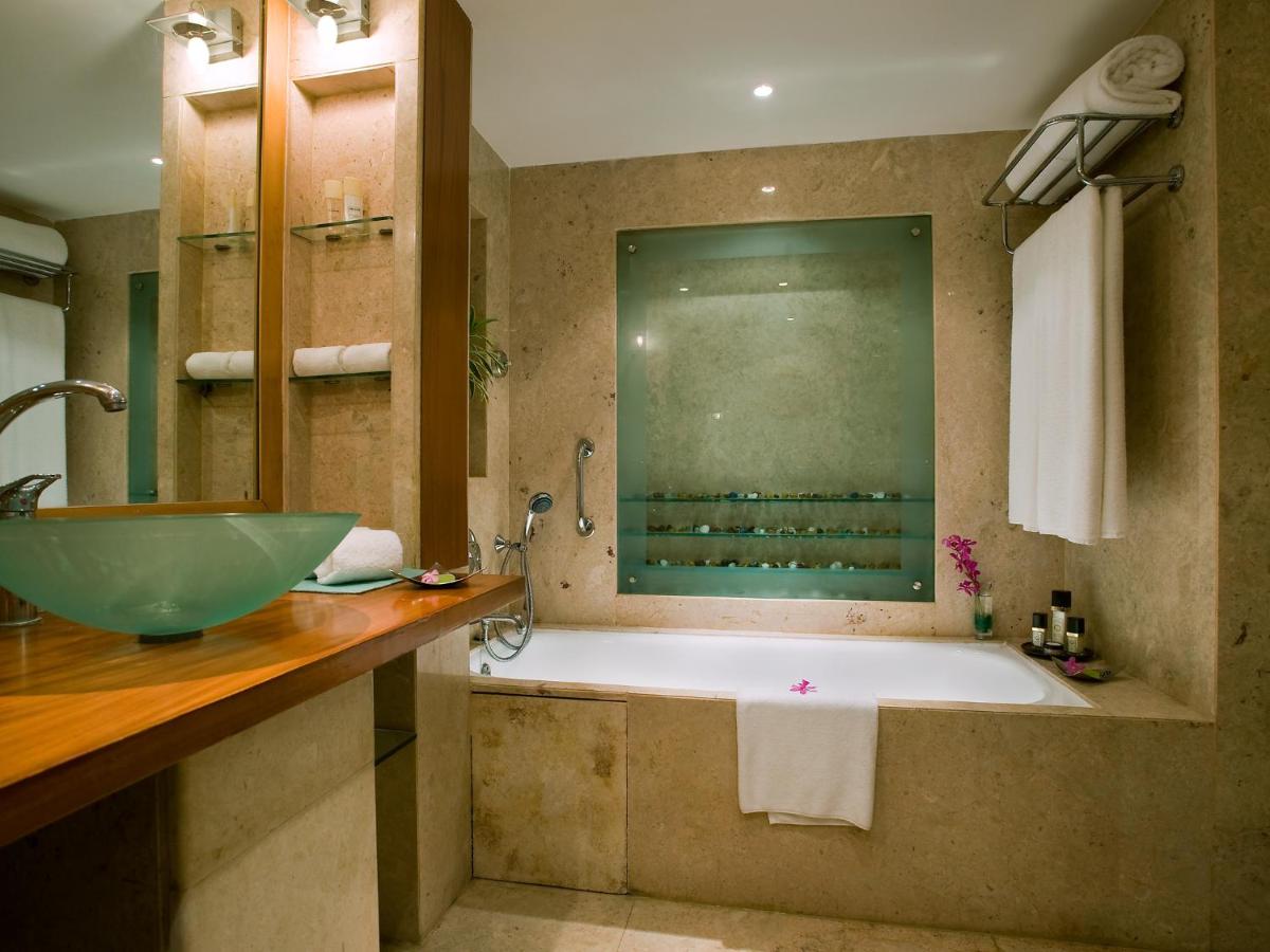 a bathroom with a large tub and a sink at The Lalit Mumbai in Mumbai