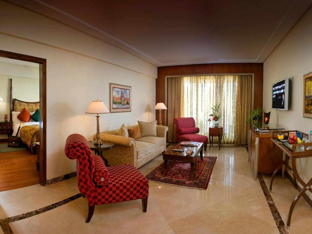 a living room with a couch and a chair and a living room at The Lalit Mumbai in Mumbai