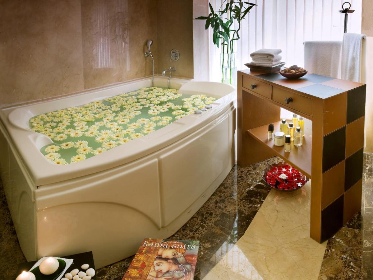 a bathroom with a bath tub with flowers on it at The Lalit Mumbai in Mumbai