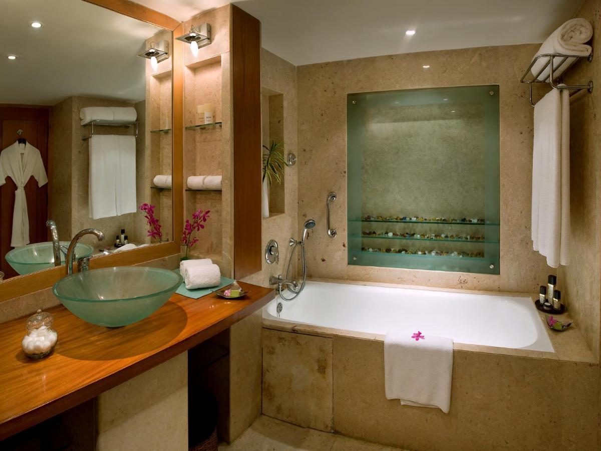 a bathroom with a large tub and a sink at The Lalit Mumbai in Mumbai