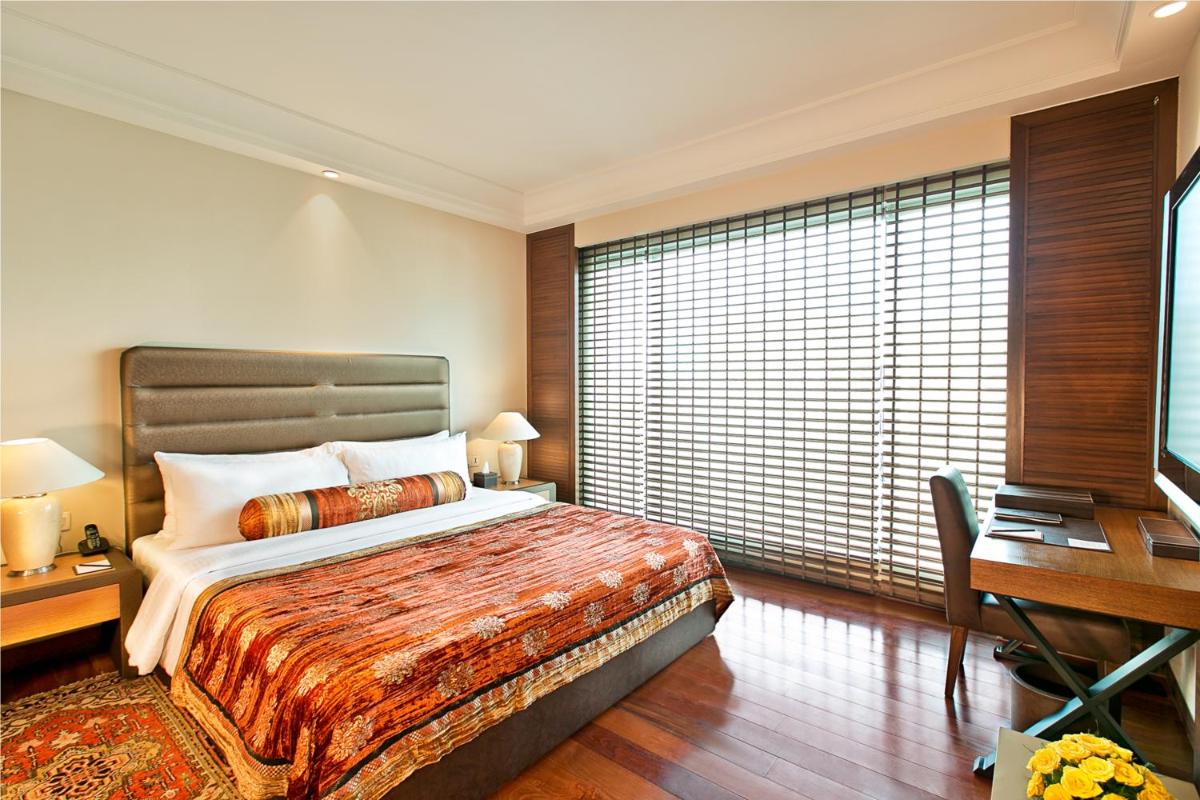 a hotel room with a bed and a desk and a desk at The Lalit Jaipur in Jaipur
