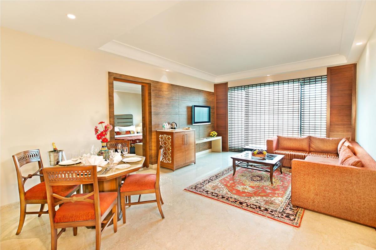 a living room with a table and a couch at The Lalit Jaipur in Jaipur