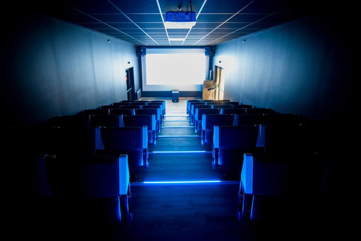 une pièce vide avec des chaises bleues dans un théâtre dans l'établissement Château L'Hospitalet Wine Resort Beach & Spa, à Narbonne 105 autres photos