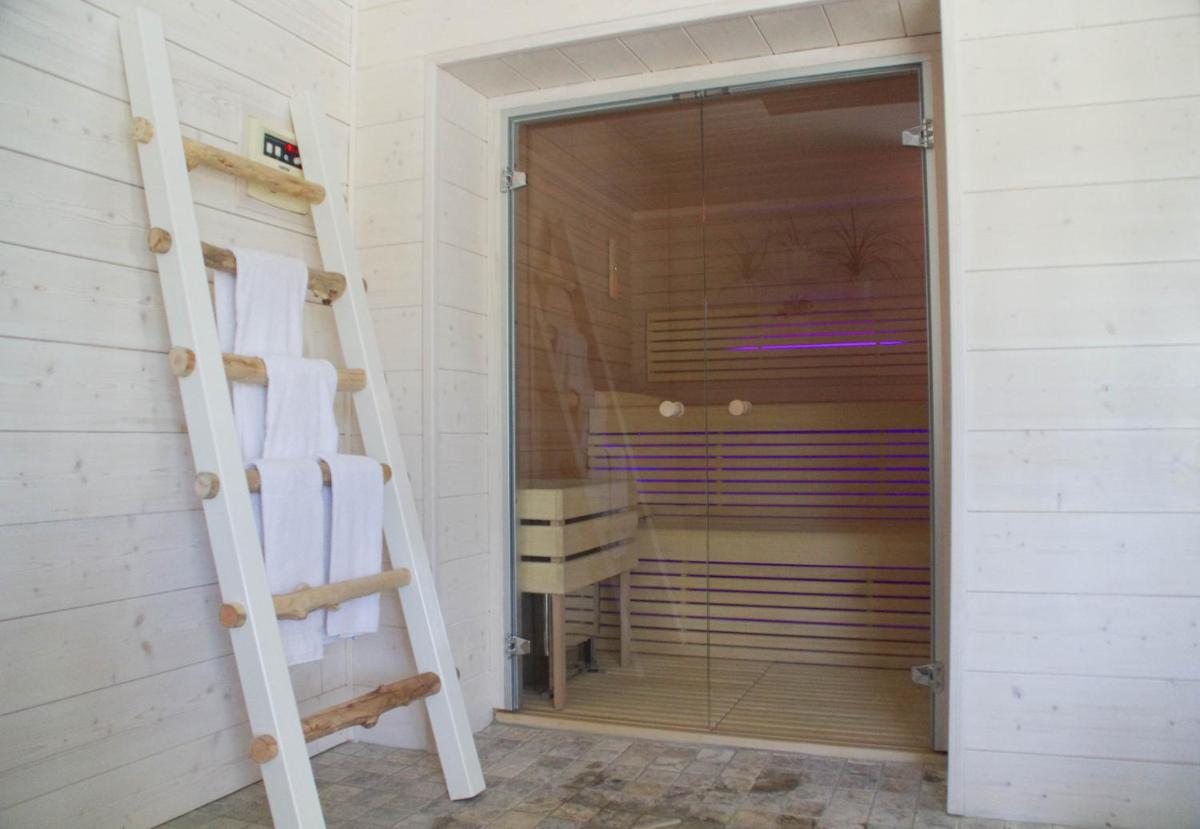 un sauna avec une porte en verre et une échelle dans l'établissement Hotel A Piattatella, à Monticello 36 autres photos