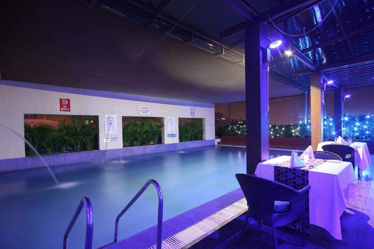 a pool with a table and chairs in a building at Fortune Select JP Cosmos, Bengaluru - Member ITC Hotels' Group in Bengaluru
