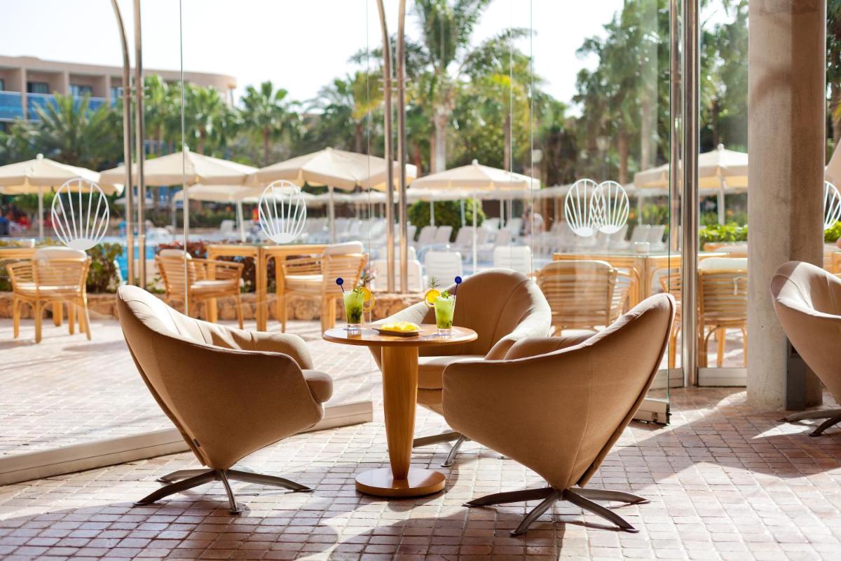 Un restaurante con sillas y una mesa con bebidas. en MUR Faro Jandia Fuerteventura & Spa, en Morro del Jable