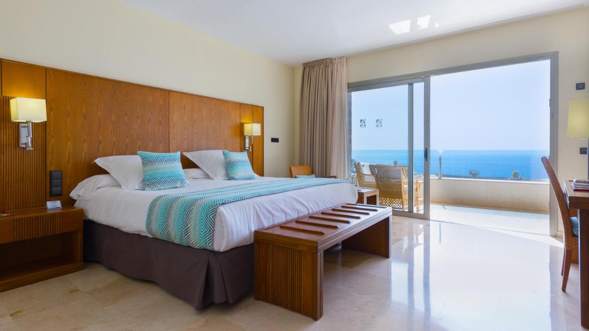 Un dormitorio con una cama grande y un balcón. en Gloria Palace Royal Hotel & Spa, en Puerto Rico de Gran Canaria