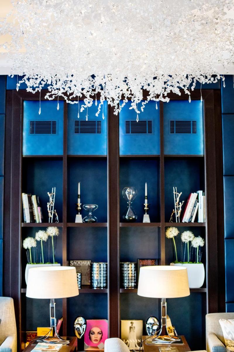un salon avec deux lampes et un mur bleu dans l'établissement Thalazur Bandol Ile Rousse - Hôtel & Spa, à Bandol