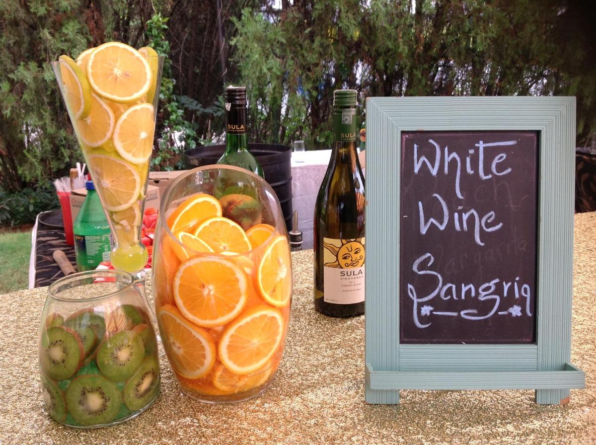 a table with a sign and bottles of wine and oranges at Hotel Royal Orchid Bangalore in Bengaluru