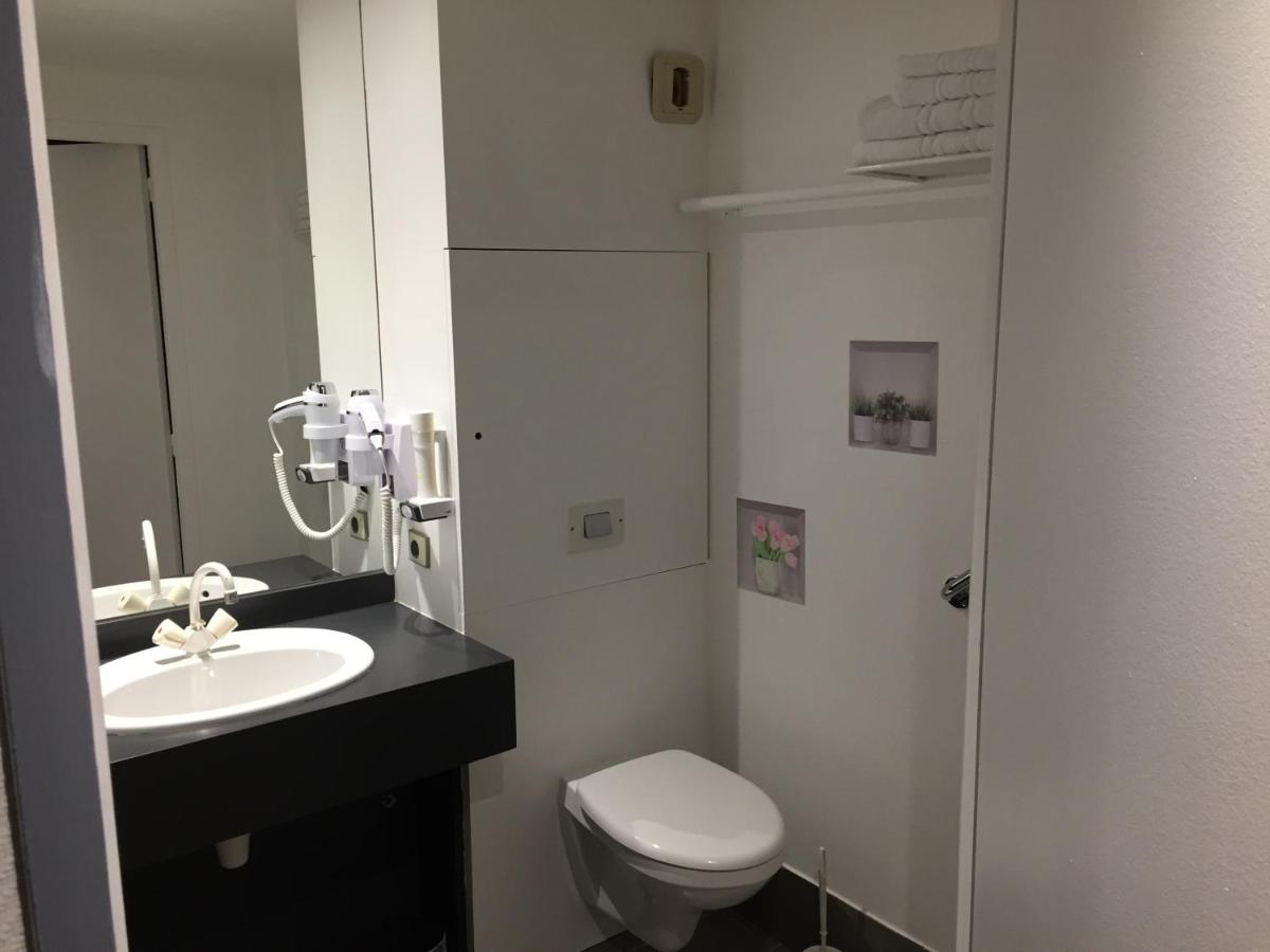 une salle de bain avec des toilettes blanches et un lavabo dans l'établissement Le Pavillon, à Cours-la-Ville