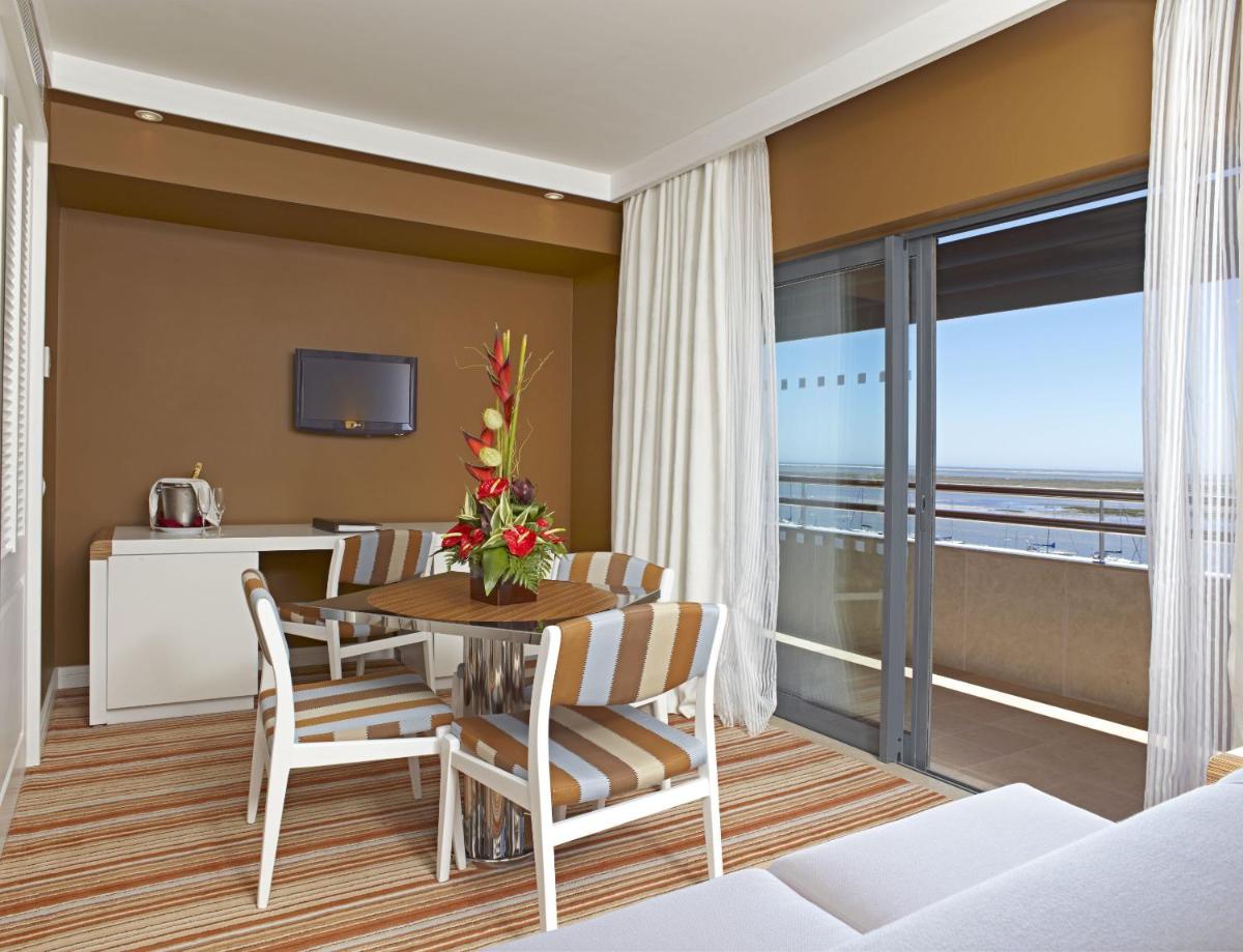 uma sala com mesa e cadeiras e uma varanda em Real Marina Hotel & Spa em Olhão