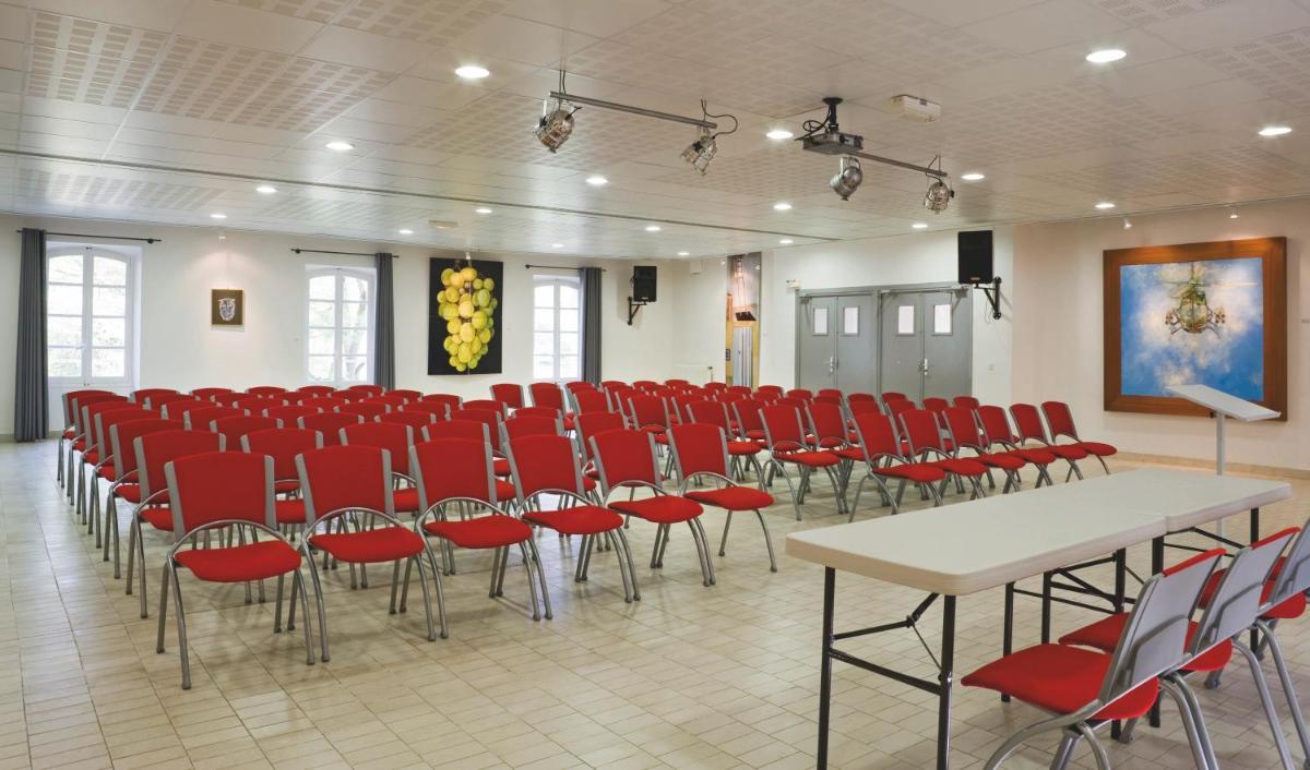 une salle de conférence avec des chaises rouges et une table blanche dans l'établissement Club Vacances Bleues Domaine de Château Laval, à Gréoux-les-Bains 46 autres photos