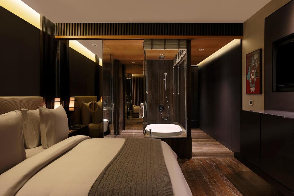 a hotel room with a bed and a bathroom at Roseate House New Delhi in New Delhi a hotel room with a bed and a bathroom at Roseate House New Delhi in New Delhi