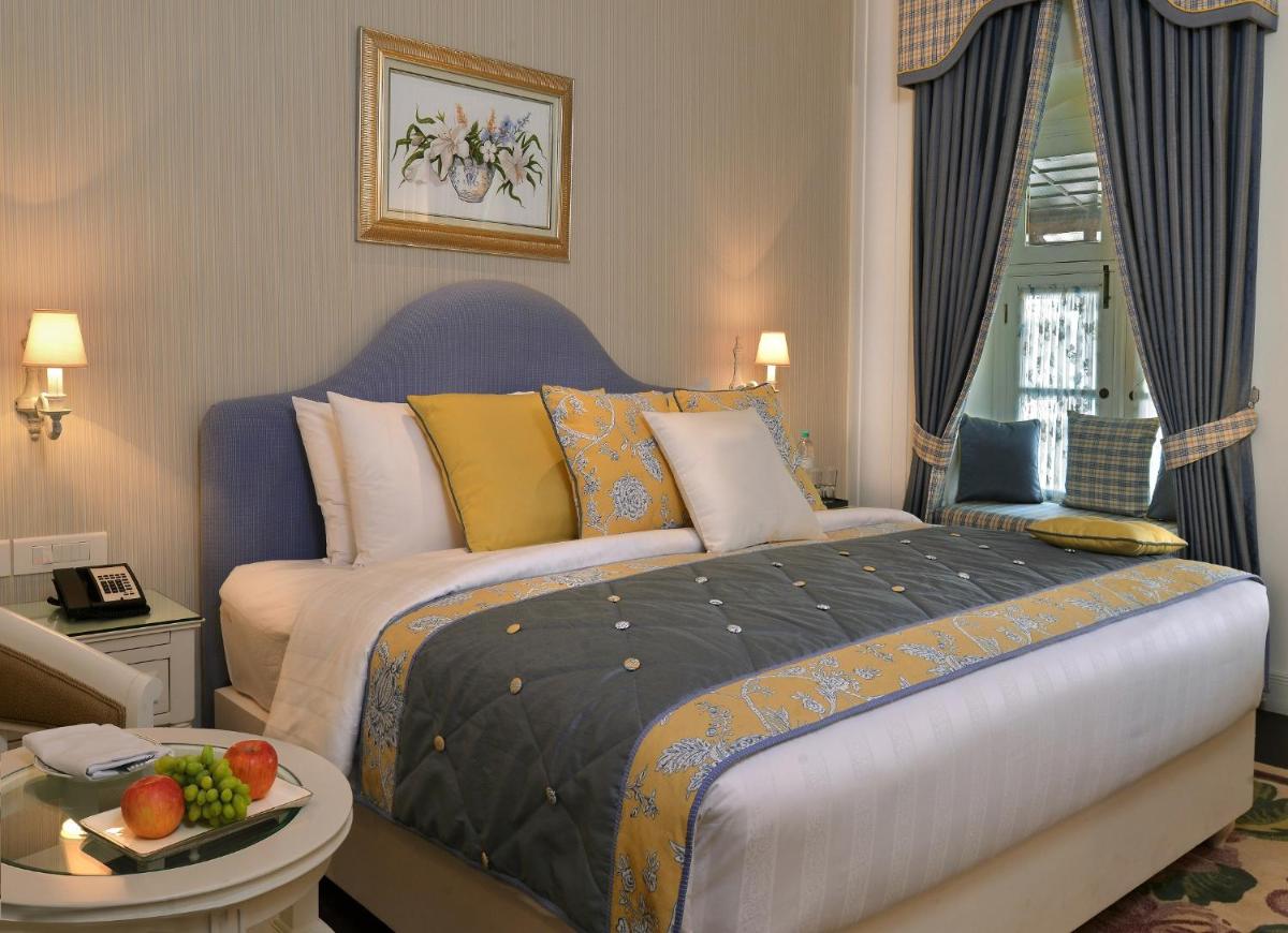 a bedroom with a bed and a table with fruit on it at Welcomhotel by ITC Hotels, The Savoy, Mussoorie in Mussoorie