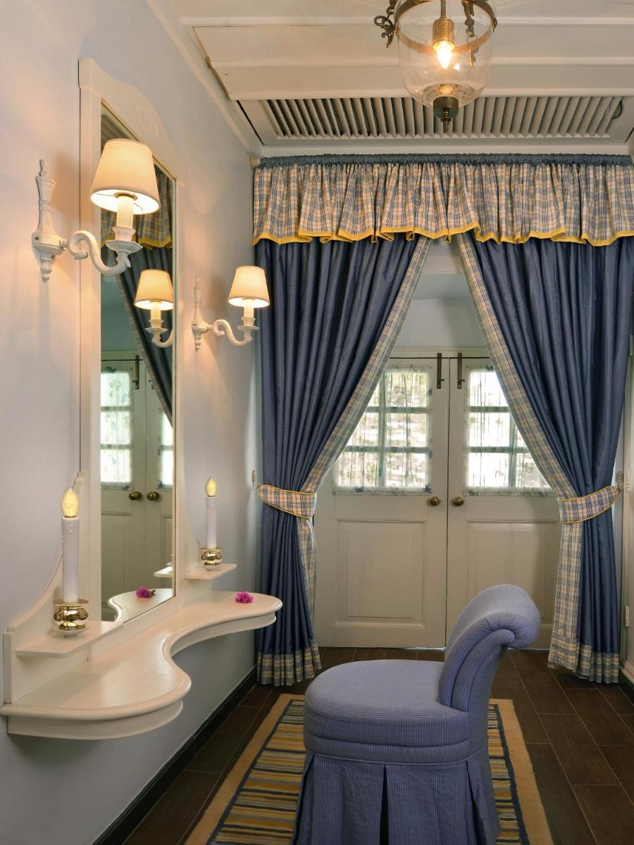 a dressing room with a blue chair and a mirror at Welcomhotel by ITC Hotels, The Savoy, Mussoorie in Mussoorie