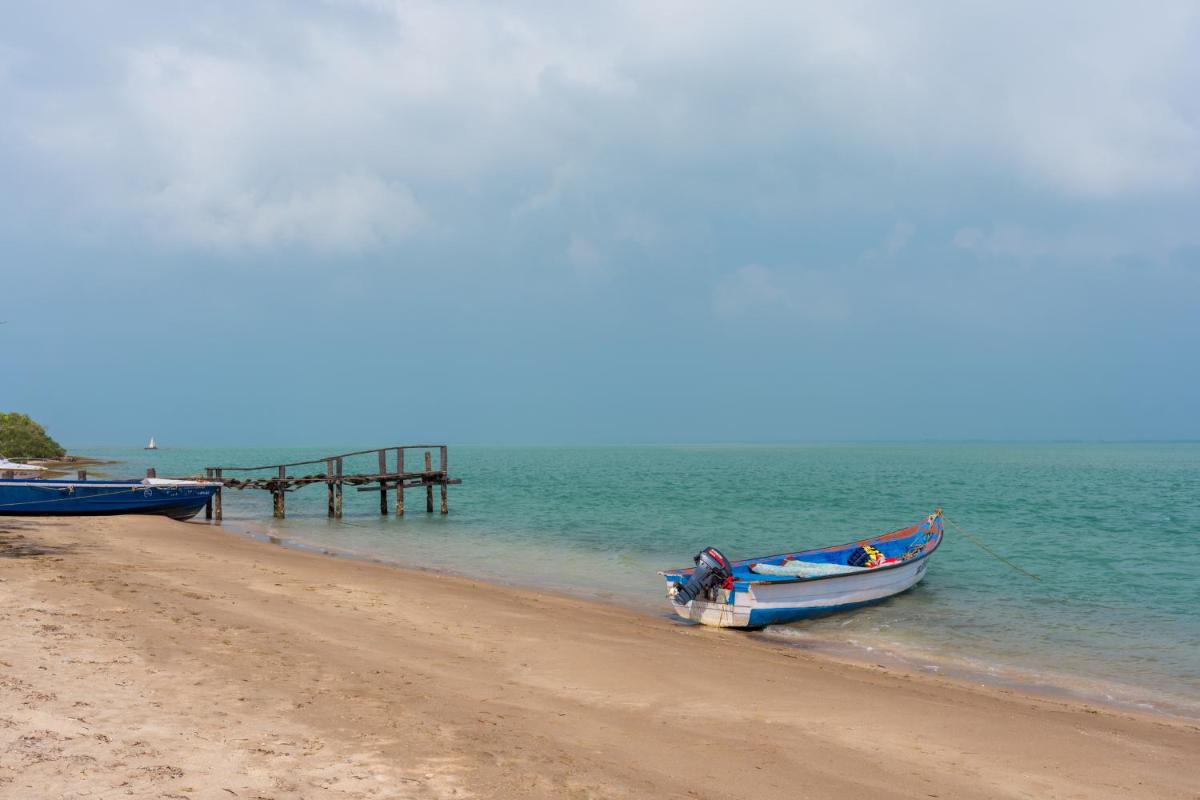 a boat sitting on the beach next to a pier at The Residency Towers, Rameswaram in Rāmeswaram